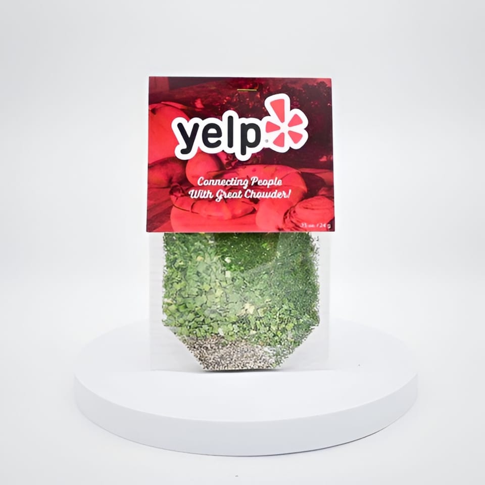 Yelp-branded seed packet with "Connecting People With Great Chowder!" text, on a white pedestal.